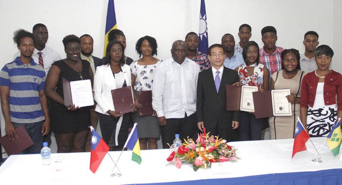 Ambassador Ger, in suit, and Minister of Education, Jimmy Prince pose with scholarship recipients on Monday. (iWN photo)