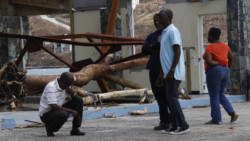 Commissioner of Customs Aubrey Forbes stoops after surveying the damage at the Jost Van Dyke ferry terminal in West End Tortola. CMC photo.jpg
