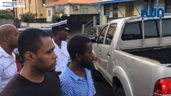 Veron Primus (in black) and other prisoners stand near the police pickup truck on Friday. (iWN photo)
