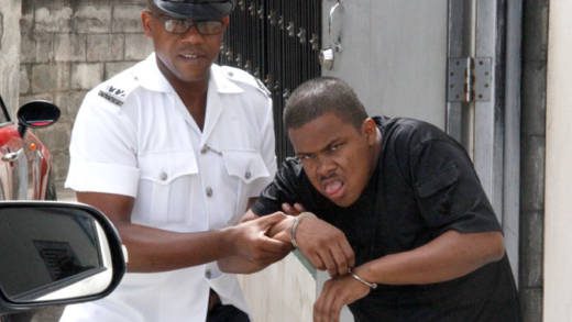 A police officer assists accused murderer Jurani Baptiste to a vehicle to be transported to hospital on Monday. (iWN photo)