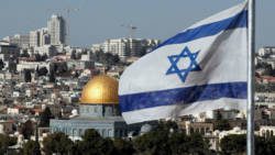 The Israeli flag flutters in front of the Dome of the Rock mosque and the city of Jerusalem.  (THOMAS COEX / AFP/GETTY IMAGES)  