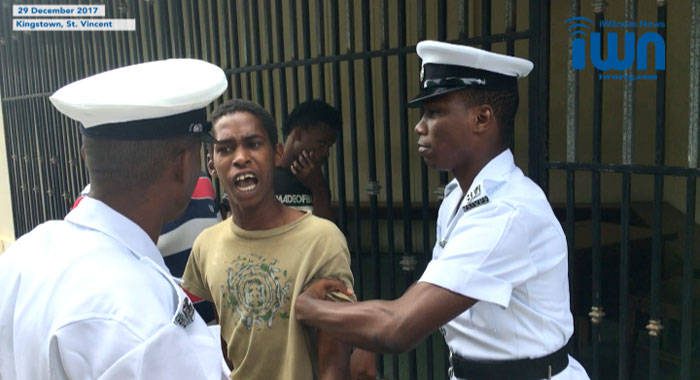 In this iWN image, captured from video, Kewan Prince,15, argues with police officers outside the Serious Offences Court on Friday. (iWN photo)