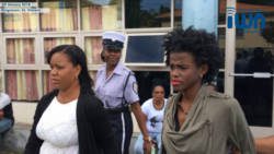 Yugge Farrell, right, is escorted from the Kingstown Magistrate's Court by plainclothes and uniformed police officers in February. (iWN image)