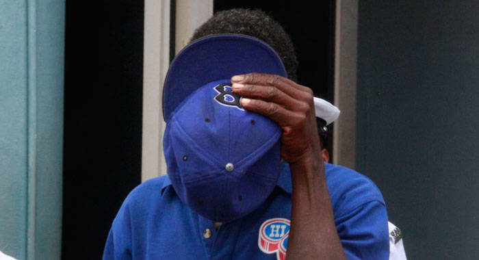 House burglar Daniel Nero uses his hat to hide his face as he is led away to prison on Tuesday. (iWN photo)