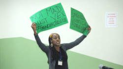 Lecturer in political science at the Cave Hill Campus, Dr. Kristina Hinds, holds up a placard during Gonsalves' lecture in Barbados on Feb. 22. (Photo: Barbados TODAY)