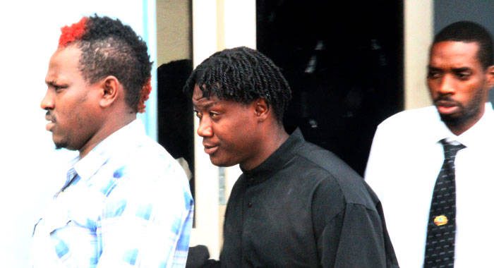 The accused men, Jevon Browne, left, and Romario Westfield, right, are escorted to court by the arresting officer, Detective Corporal Philbert Chambers on Monday. (iWN photo)