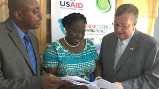 St. Vincent and the Grenadines Minister of Social Development and Youth Affairs Frederick Stephenson, left, discussing the Draft Child Justice Bill developed under USAIDs Juvenile Justice Reform  Project with Grace-Ann Cornwall, head of the Social Development Unit OECS, center, and Christopher Cushing, mission director USAID Eastern and Southern Caribbean at the ceremony to mark the re-opening of the Liberty Lodge Boys Training Centre.