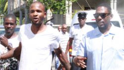 Detective Corporal Biorn Duncan, left, escorts Mwata Henry, centre, and Dwayne Sniper Stevens to court on Monday. (iWN photo) 