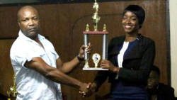 Police champion public speaker, Police Constable  Sylvorne Lavia, accepts her trophy from police chief Colin John.  