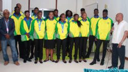 Minister of Sport, Cecil "Ces" McKie, rights, speaks with members of the SVG CARIFTA team and sports administration at Argyle International Airport on Tuesday. (iWN photo)