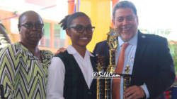 Iana Ferguson, flanked by her mother, receives her award from Prime Minister Ralph Gonsalves. (Photo: Silkcam Services/Facebook)