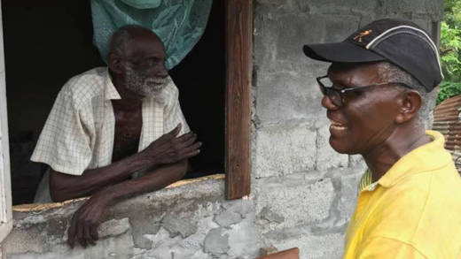 In this undated photo published recently on Facebook, former Member of Parliament for North Windward, Monty Roberts, interacts with an unidentified constituent. 