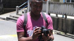A videographer hired by the Morgans records journalists outside the Kingstown Magistrate's Court. (iWN photo)