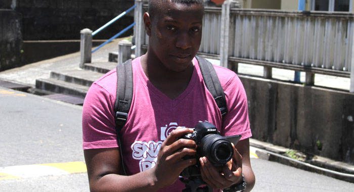 A videographer hired by the Morgans records journalists outside the Kingstown Magistrate's Court. (iWN photo)