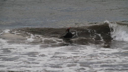 A civilian diver enters the characteristically rough seas at Breakers Monday Morning. (iWN photo)