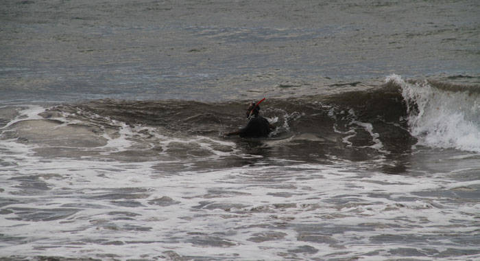 A civilian diver enters the characteristically rough seas at Breakers Monday Morning. (iWN photo)