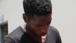 The accused, Clifton Williams, lowers his head in an attempt to avoid being photographed outside the Serious Offences Court on Monday. (iWN photo)