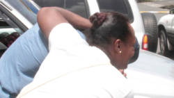 Desroy Gaymes' mother helps him to hid from reporters attempting to photograph him as he exited the Kingstown Magistrate's Court on Wednesday. (iWN photo)