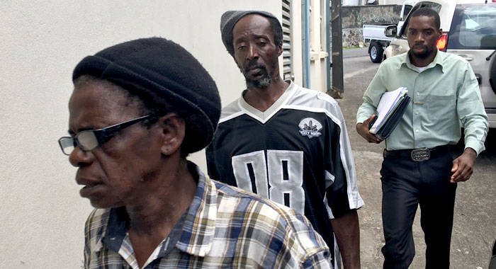 Detective Corporal Philbert Chambers, left, escorts Gailene Farrell, right, and her common-law husband, Calvert Charles to the Serious Offences Court in Kingstown on Friday. (iWN photo)