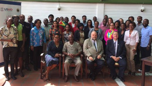 Workshop participants with, seated from left to right, Juliette Bynoe-Sutherland, Chief of Party, USAID Local Solutions Project; Keith Scott, Minister in the Ministry of Social Protection, Guyana; Perry Holloway, U.S. Ambassador to Guyana, and USAID Mission Director Christopher Cushing. 