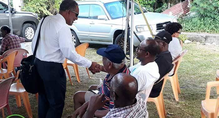Opposition Leader Godwin Friday greets persons at the NDP's Arrowroot Forum in Owia on Sunday. (NDP photo)