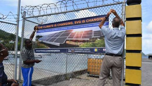 Community members in Bequia assist with hanging the banner.