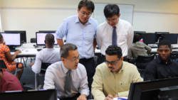 Project Manager David Fu, standing left, Senior Engineer Yu-Che Huang, standing right, Director Tsu-Wei Kao, sitting left, in discussion with a Vincentian official.
