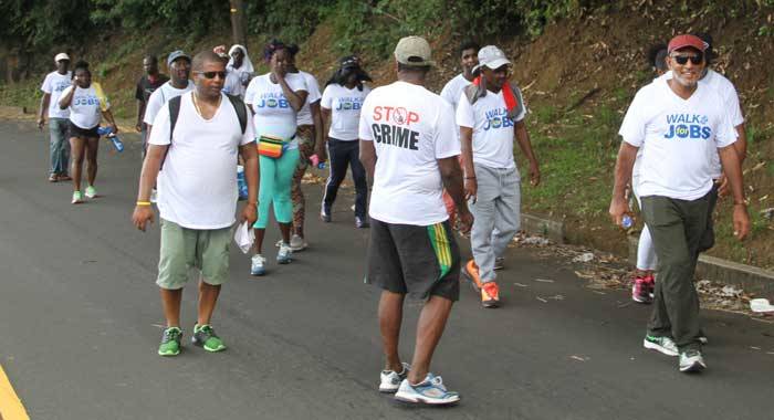 Opposition Leader Godwin Friday, left, leads the walk against crime and for jobs on Saturday. (iWN photo)
