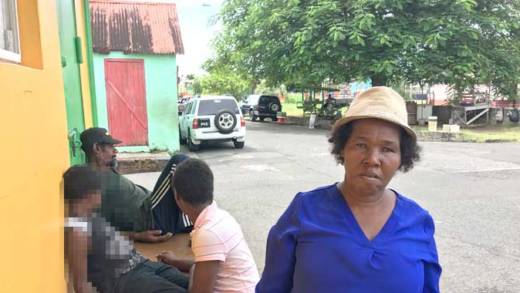 Inola Haynes and her family, three of whom, including her 6-year-old son, are seen in the background, have been living under the tree seen in the background for months. (iWN photo)