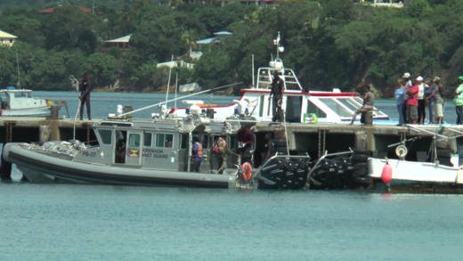 Grenada Coast Guard officers prepare to hand over Vincentian murder suspect, Joel Gary Barker, to their Vincentian counterparts on Friday. (Photo: Kendel Mark)