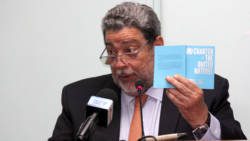 Prime MInister Ralph Gonsalves holds up a copy of the UN Charter at Monday's event in Kingstown. (iWN photo) 