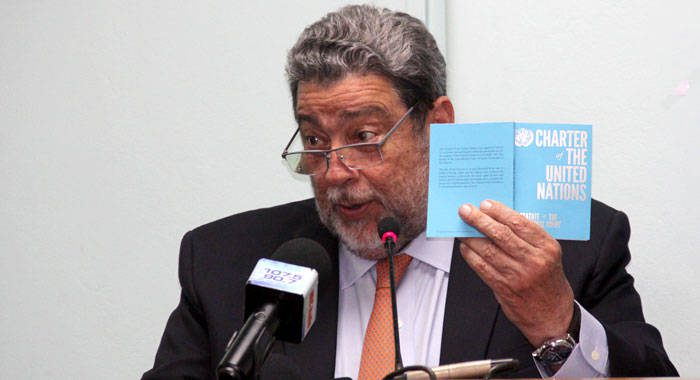 Prime MInister Ralph Gonsalves holds up a copy of the UN Charter at Monday's event in Kingstown. (iWN photo) 