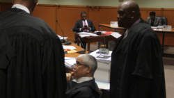 Petitioner Benjamin Exeter, in background, is framed by lead counsel for the government, Douglas Mendes, centre, and Kenny Kentish, during a break in Tuesday's proceedings. (iWN photo)