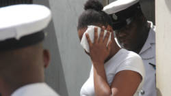 Kamai Jack uses a tissue to hide her face as she leaves the court on Friday. (iWN photo)