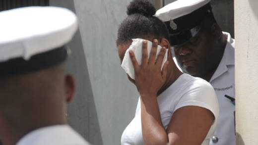 Kamai Jack uses a tissue to hide her face as she leaves the court on Friday. (iWN photo)