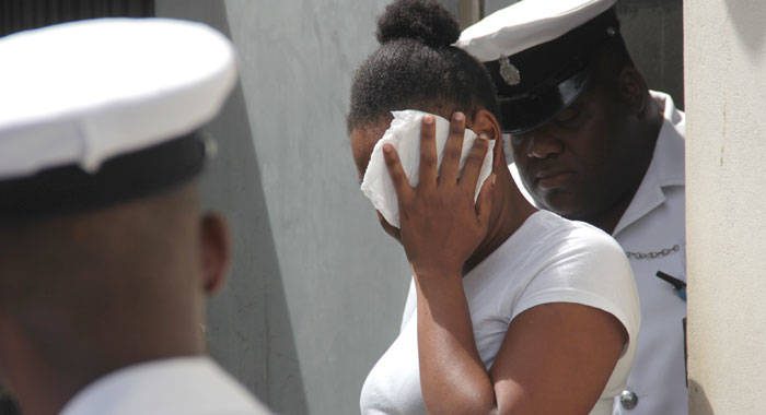 Kamai Jack uses a tissue to hide her face as she leaves the court on Friday. (iWN photo)