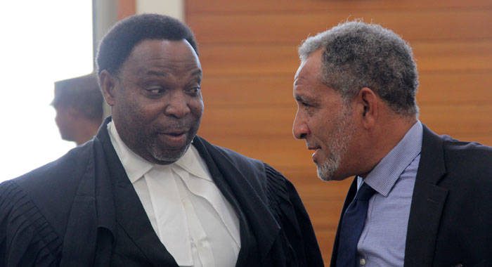 Keith Scotland, senior counsel in the North Windward petition, left, chats with Opposition Leader Godwin Friday outside the courtroom last Wednesday. (iWN photo)