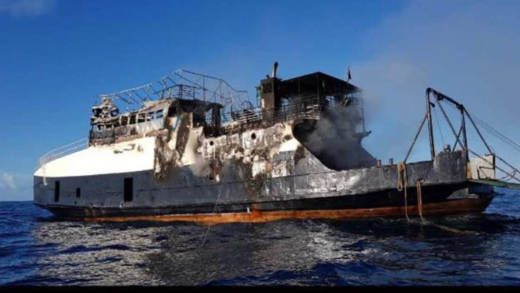 The burnt-out hull of the MV Gem Star afloat at sea on Wednesday, before it was towed back to shore. (Photo: Carron Djsarda Hinds/Facebook)