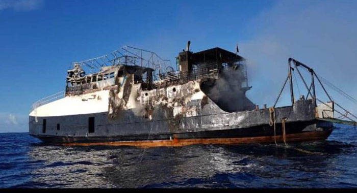 The burnt-out hull of the MV Gem Star afloat at sea on Wednesday, before it was towed back to shore. (Photo: Carron Djsarda Hinds/Facebook)