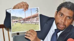 Minister of Finance, Camillo Gonsalves holds up an artist impress of one of the hotels that his government plans to build. (Photo: Lance Neverson/Facebook)