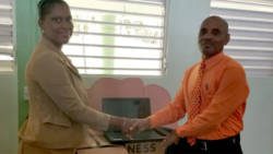 Shevern Lewis-John, who represented the donors, hands over the equipment to Colbert Bowens, head teacher of the Fancy Government School. 