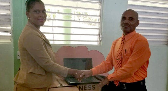 Shevern Lewis-John, who represented the donors, hands over the equipment to Colbert Bowens, head teacher of the Fancy Government School. 