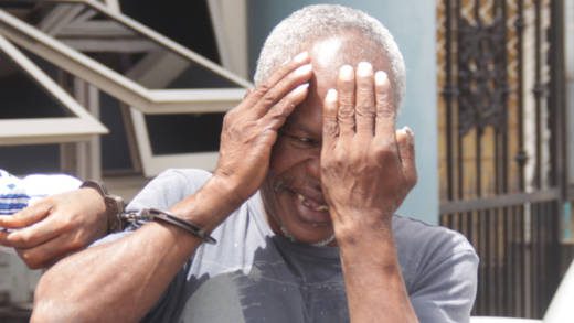Bertram Wright hides his face as he leaves the court for prison on Tuesday. (iWN photo)