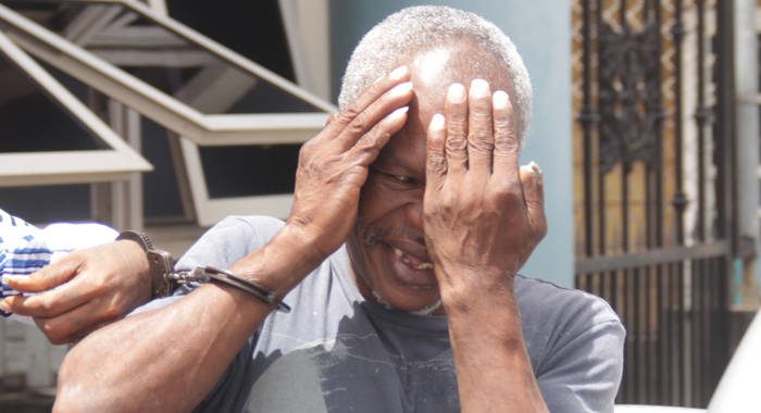Bertram Wright hides his face as he leaves the court for prison on Tuesday. (iWN photo)