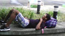 The injured Richardo Stewart lying on a wall outside Argyle International Airport awaiting transportation to a hospital Friday morning. 