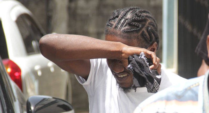 Burglary Jeffery Jordon hides his face as he is escorted to prison after his arraignment on July 23. (iWN photo)