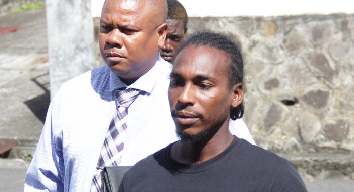 Attempted murder accused Romando Bruce, right, is escorted to court by the lead investigator, Detective Corporal Dwight James, on Wednesday. (iWN photo)