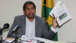 Minister of Finance Camillo Gonsalves holds up the bid evaluation report at a press conference in Kingstown on Tuesday. (iWN photo)