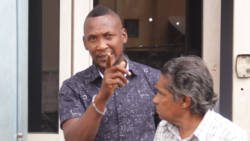 Paul Stephens, left, the complainant in the matter became aggressive as soon as he exited the court building. He is filed her gesturing at Kenton X. Chance of iWitness News. Journalist Hadyn Huggins is in the forefront. (iWN photo)