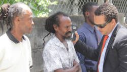 Lawyer Grant Connell, right, speaks with his clients, Alvin Williams, centre, and Irwin Thomas outside the Serious Offences Court on Wednesday. (iWN photo)